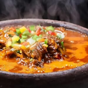 Aromatisches Gericht mit Thunfisch, gegart in einer wässrigen Tomatenmarksoße mit Zwiebeln, Lauchzwiebeln, süßer Spitzpaprika, Knoblauch, Koriander, Kartoffeln, Karotten, Auberginen und Zucchini. Serviert im traditionellen Tontopf - wahlweise mit Brot oder Reis. Die ausgewogene Kombination aus Gemüse und Gewürzen macht dieses Gericht zu einem besonderen Genuss.^C.6